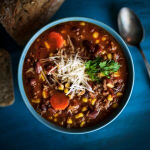 Delicious homemade beef chili served with fresh bread on a rustic table for a cozy meal.